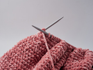 Wool yarn in different colors with wooden double point needles. The needles are being used for knitting socks, mittens or other projects joined in the round.