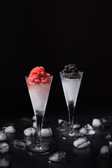 Caviar de esturión negro y caviar de salmón rojo servido en copa de cóctel helada sobre fondo negro	