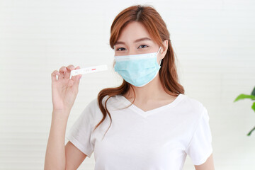 ฺbeautiful asian woman She was wearing a blue mask. She is sick with the flu, stays at home and...
