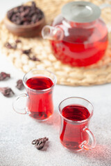 Red tea carcade in glasses and dried hibiscus flowers.