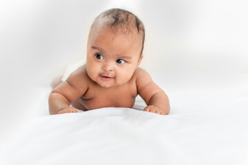 Portrait images of African baby newborn girl is 3 month year old, Lying on white bed in bedroom, to African newborn concept.