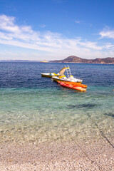 Pedal boats and kayak in the clear water of Padulella beach, Island of Elba, Italy