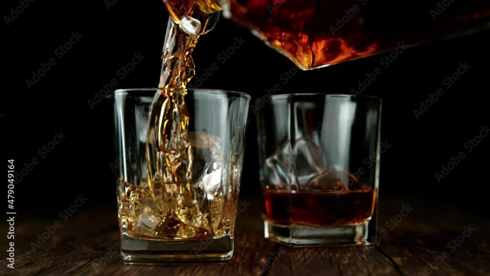 Fototapete Super slow motion of pouring whiskey or rum with slide motion.  Speed ramp effect. Filmed on high speed cinema camera. Speed ramp effect.