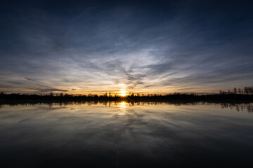 Fototapeta na wymiar Beautiful sunset landscape sunset on the lake, reflected on the calm water - France