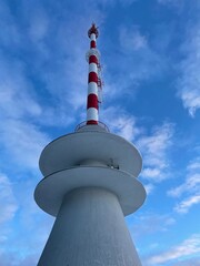 Obraz premium Low angle view of television tower against blue sky. Vertical.