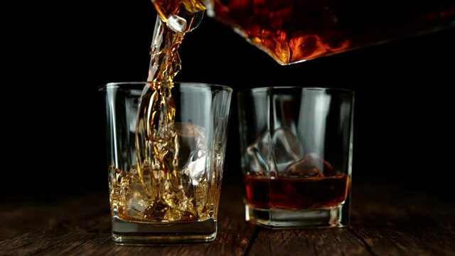 Super slow motion of pouring whiskey or rum with slide motion.  Speed ramp effect. Filmed on high speed cinema camera. Speed ramp effect.
