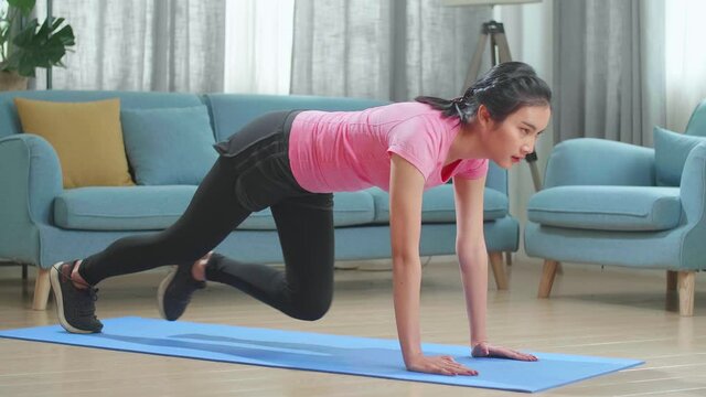 Fitness Asian Female Is Doing Mountain Climber Exercises In Her Home
