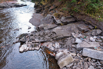 River stream running past mountain foot with autumn forest