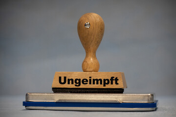 on a wooden stamp is written the german word ungeimpft
