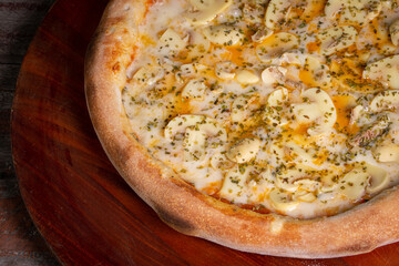 Tasty Mushroom Pizza on wooden background, in Brazil it's called pizza de cogumelos.