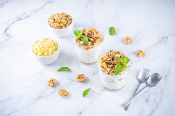 Obraz na płótnie Canvas Greek yogurt millet caramelized apple walnuts parfait in a glass