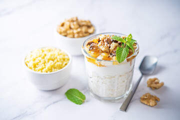 Fototapeta Greek yogurt millet caramelized apple walnuts parfait in a glass obraz