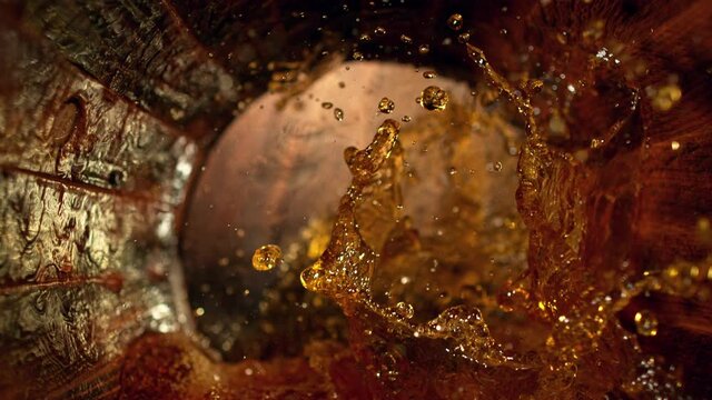 Super Slow Motion Shot of Splashing Whiskey in Old Oak Barrel at 1000fps.