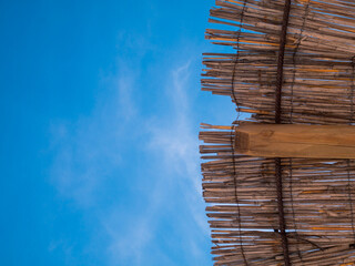 Part of the straw beach umbrellas and View of the beautiful blue sky