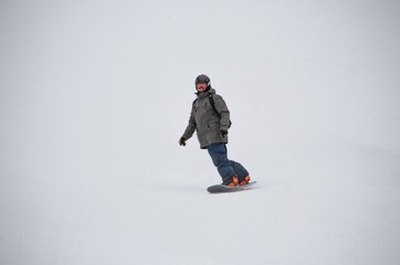 a man on a snowboard rides down the side of the mountain