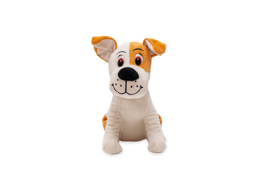 Cute dog doll isolated on white background. Soft plush toy dog looking cute straight into the camera.