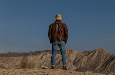 Rear view of adult man legs standing on cliff in Tabernas Desert, Almeria, Spain