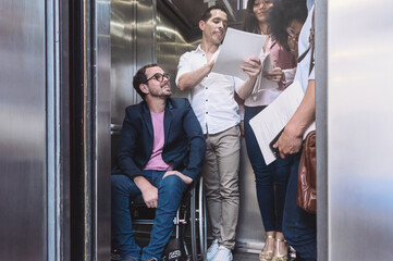 group of people with man in wheelchair inside an elevator - obrazy, fototapety, plakaty