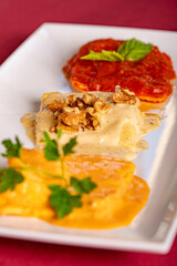 A Trio of Large Ravioli on a plate with three types of sauce.
