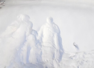Three prints of figures in the snow. Family of snow angels. Selective focus.