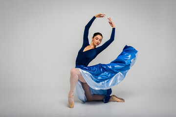 Modern ballet dancer exercising in full body on white studio background. Ballerina or female dancer...