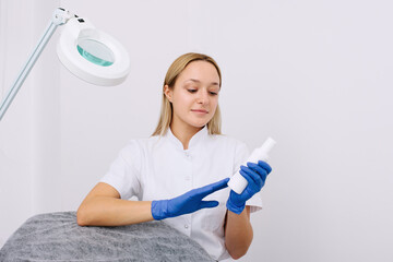 Portrait of female professional beauty doctor with a product in a hand.