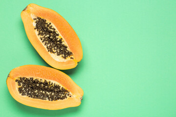 Papaya on a green background, top view, copy space