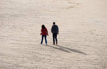 Fototapeta na wymiar couple walking on the sand on the beach