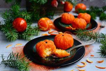 Ideas for New Years snacks. Dessert in the form of tangerines on a green plate and New Year's decor on a light background