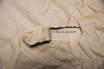 Uncovering a freedom. There is a hole in the craft paper, the word love is printed in it.