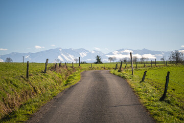Countryside road in southwestern France with the Pyrenees mountains in the background