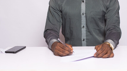 african man sitting for a job interview, filling a form