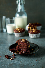 Chocolate muffin with hazelnuts and milk in background. Homemade cake