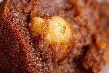 Beautiful candy truffle with a nut inside on a white plate on a black background