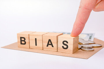 four wooden cubes with word BIAS on gray working board.