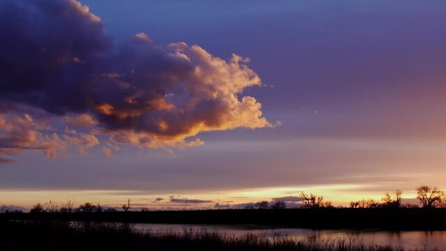 Time lapse cloud over river at sunset