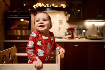 baby boy in pajamas in Christmas kitchen. High quality photo