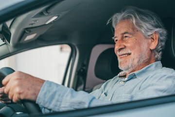 Happy owner. Handsome bearded mature man sitting relaxed in his newly bought car looking out the...