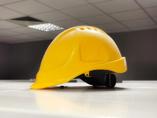Yellow helmet in the factory dressing room. Safety regulations concept - obrazy, fototapety, plakaty