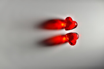 Dramatically Lit Studio mage of Two Sparkling Red Gemstone Hearts on a Grey Studio Background