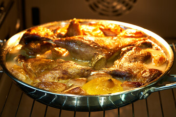 the duck lies in a skillet in the oven