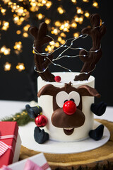 Traditional Christmas cake with fruits, nuts and white glaze with Christmas decorations