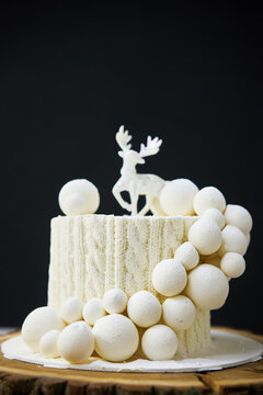Traditional Christmas cake with fruits, nuts and white glaze with Christmas decorations