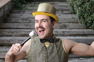 Showman with golden outfit holding microphone