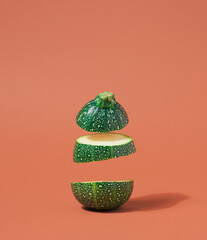 Round squash slices dropping against the pastel brown background. Organic diet ingredients concept
