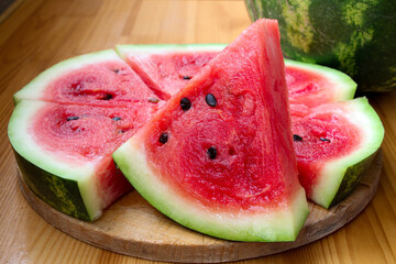 Slices of red watermelon on a wooden background