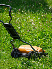 Hand-held lawnmower outside on the lawn.