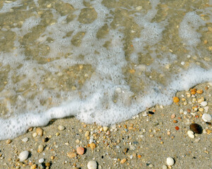 Cape May surf washing up in small waves over shells and pebbles on the shoreline