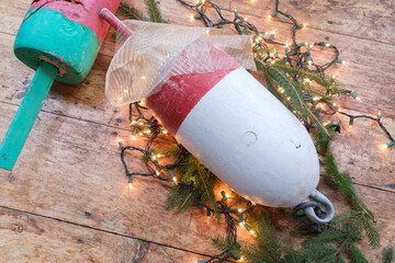 Colorful Maine Red green and white lobster float buoys surrounded by Christmas holiday lights