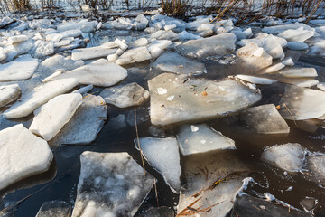 Close up view of ice drift on the frozen river. Melting ice. Flooded road. Concept of spring floods